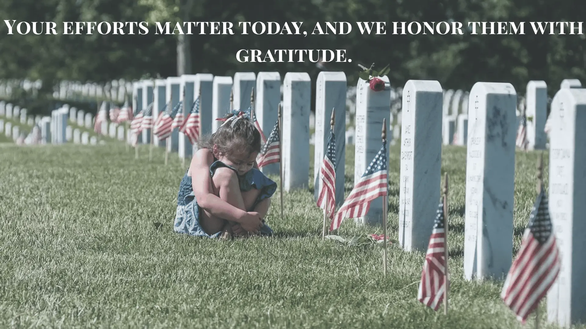 Young girl sitting by gravestones with American flags, reflecting and honoring the fallen heroes on Memorial Day.