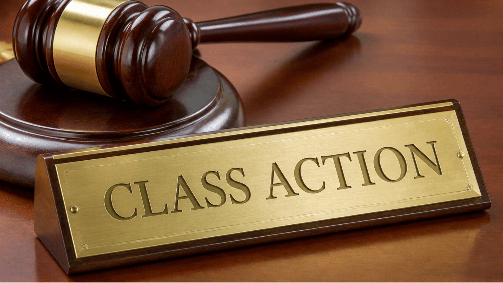 A judge's gavel resting next to a gold nameplate engraved with 