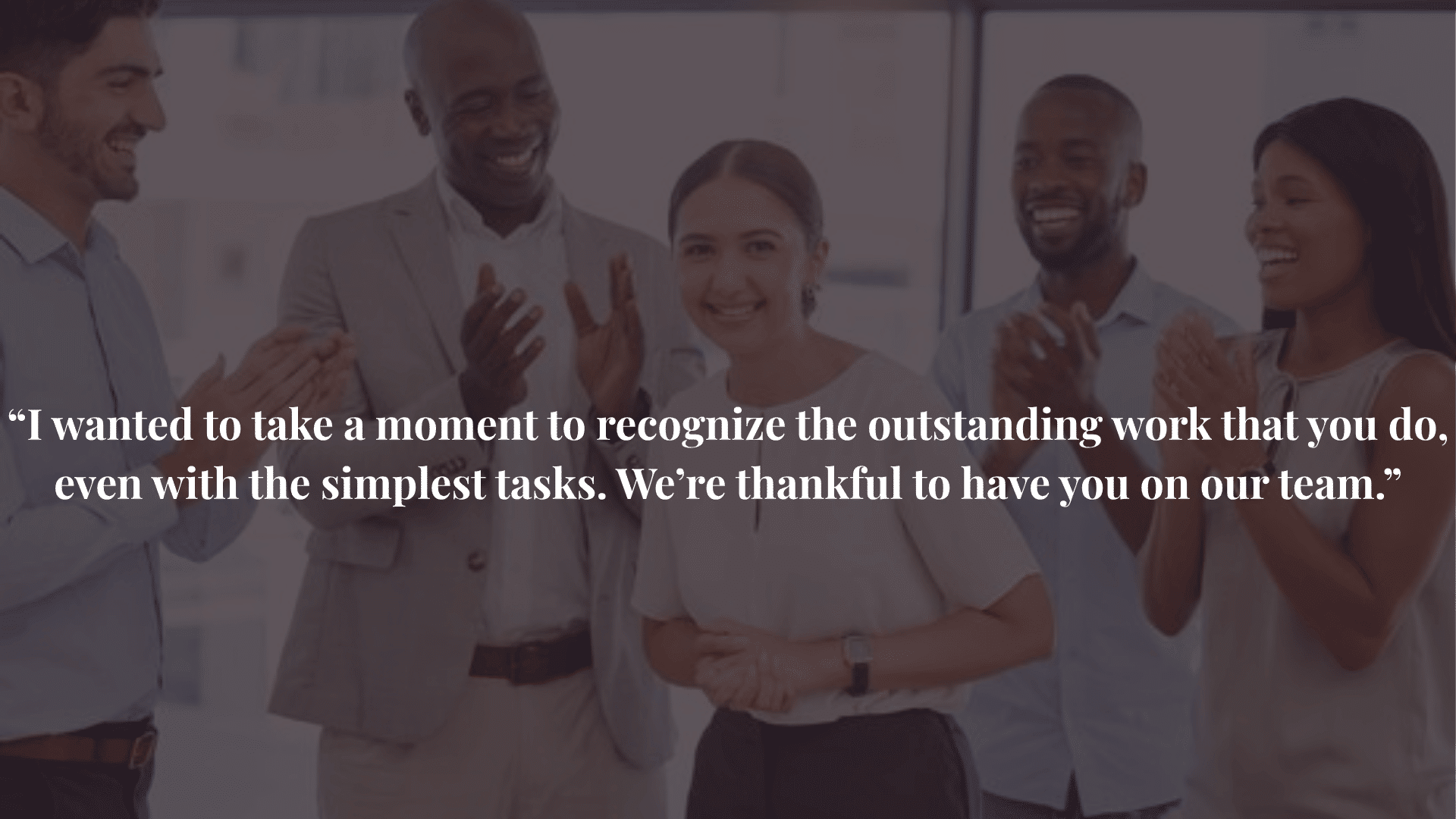 Colleagues applauding a smiling woman in office, recognizing her achievement and contribution to the team