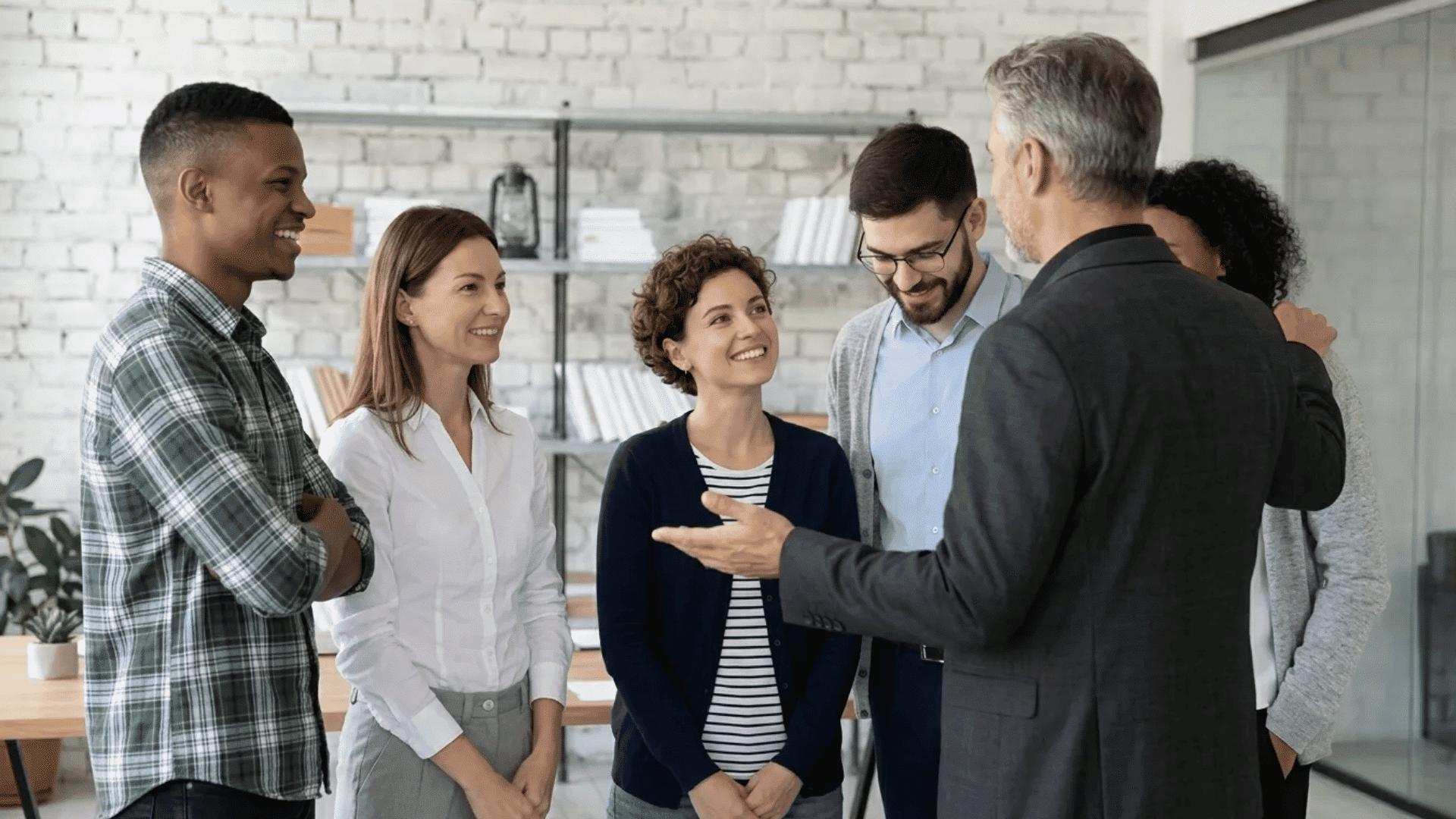 Coworkers being appreciated by a team leader during a positive and encouraging office discussion.