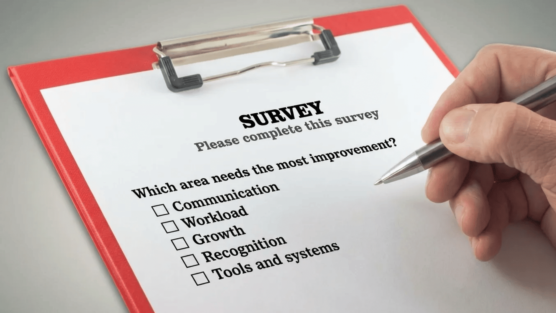 Employee engagement survey questions on a clipboard with options for communication, workload, growth, recognition, and tools.