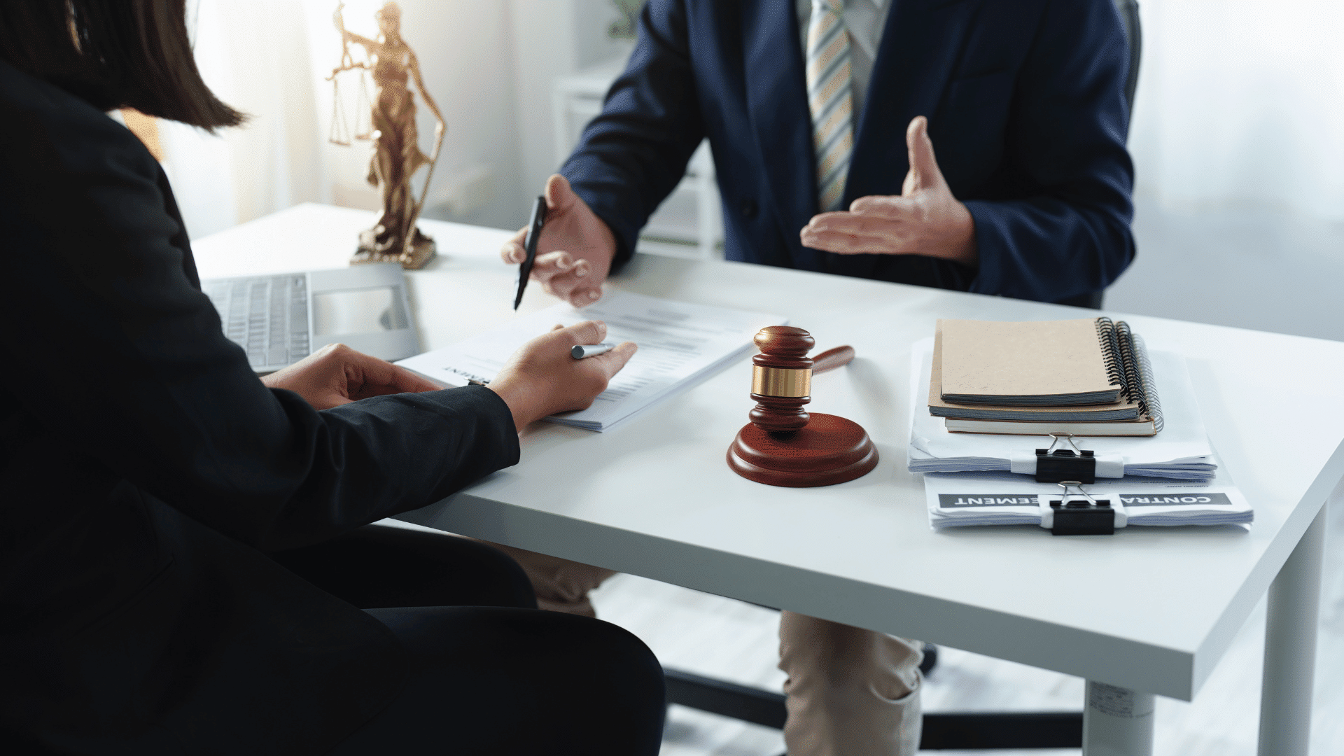 Erisa attorney consulting a client across a desk with a gavel and legal documents