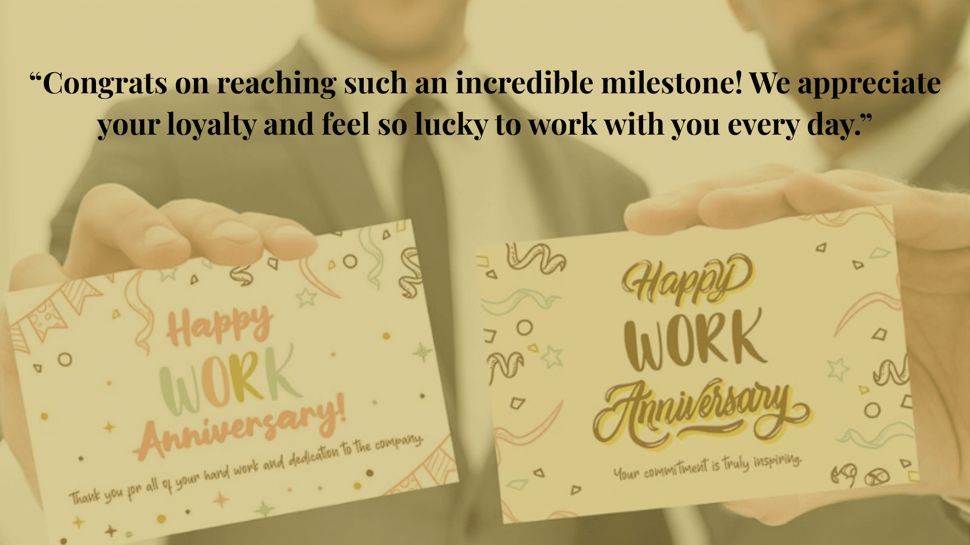 Two men in suits holding cards that say 'Happy Work Anniversary' with messages of appreciation and dedication