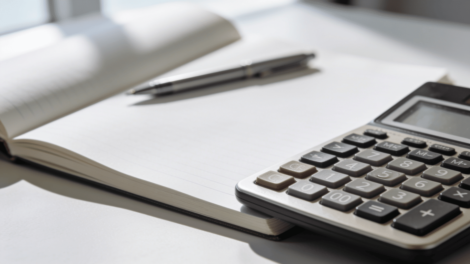Calculator and notebook used to compute total work hours in a year