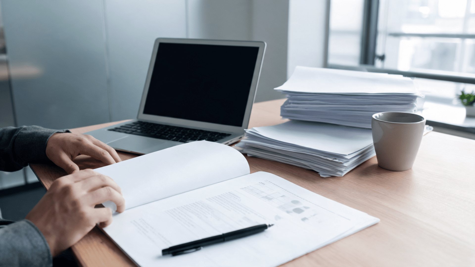Documents and laptop showing a completed background screening report review process